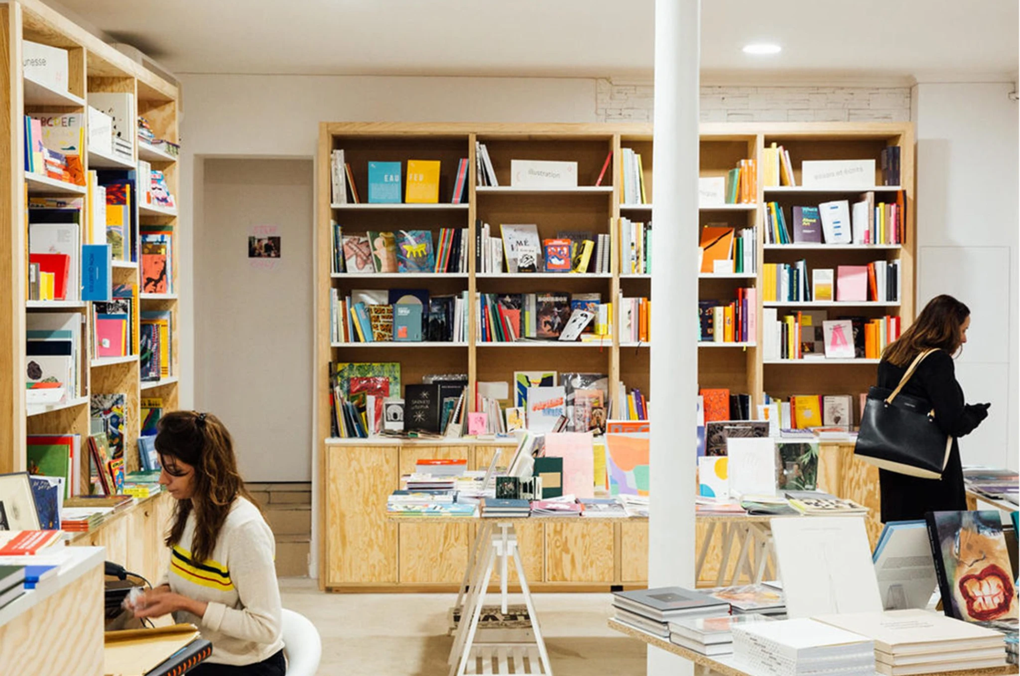 Interior of Librairie Sans Titre in Paris with wooden bookshelves and independent art and design publications on display.