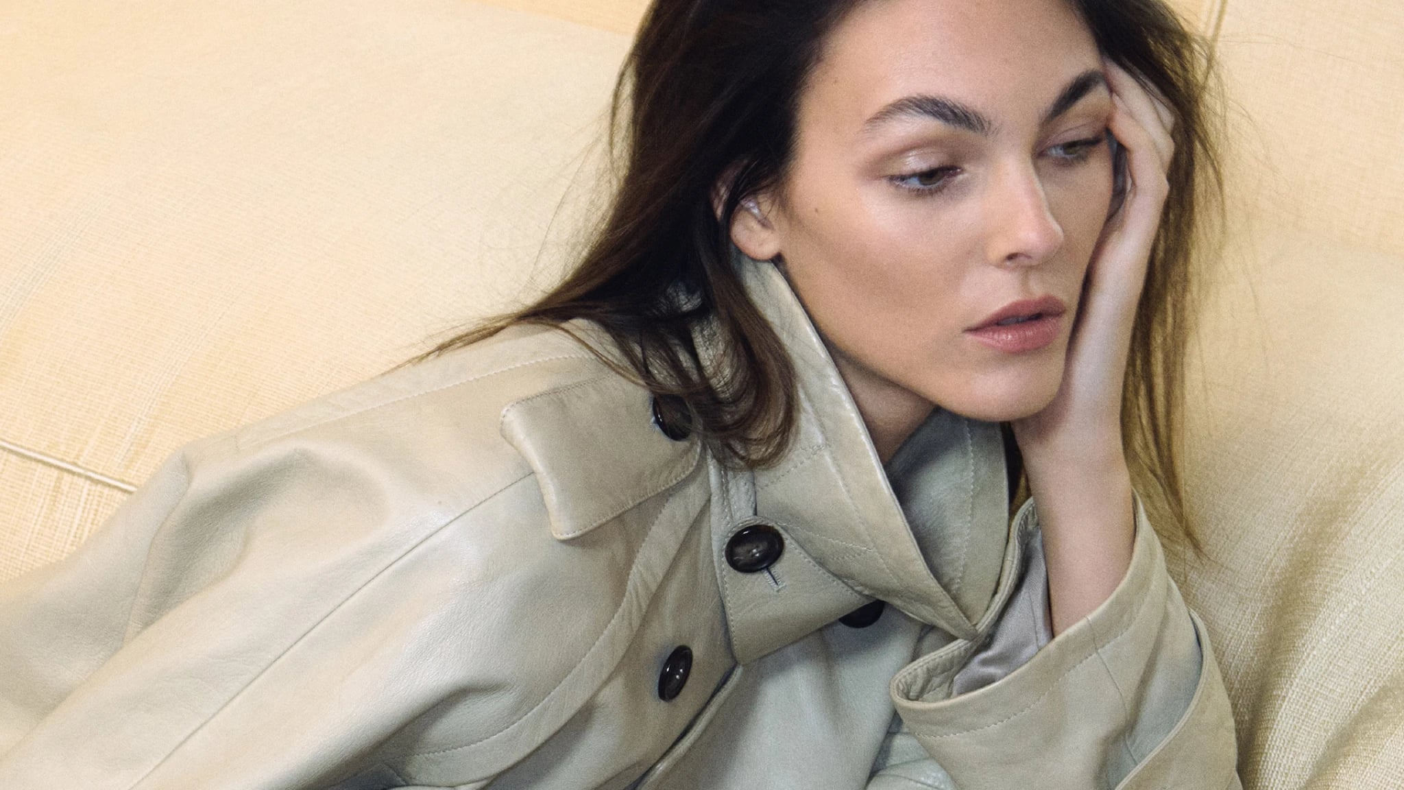 Vittoria Ceretti photographed for the Giorgio Armani Spring Summer 2026 campaign, wearing a neutral toned leather coat and holding a structured Armani handbag inside a Milan residence.