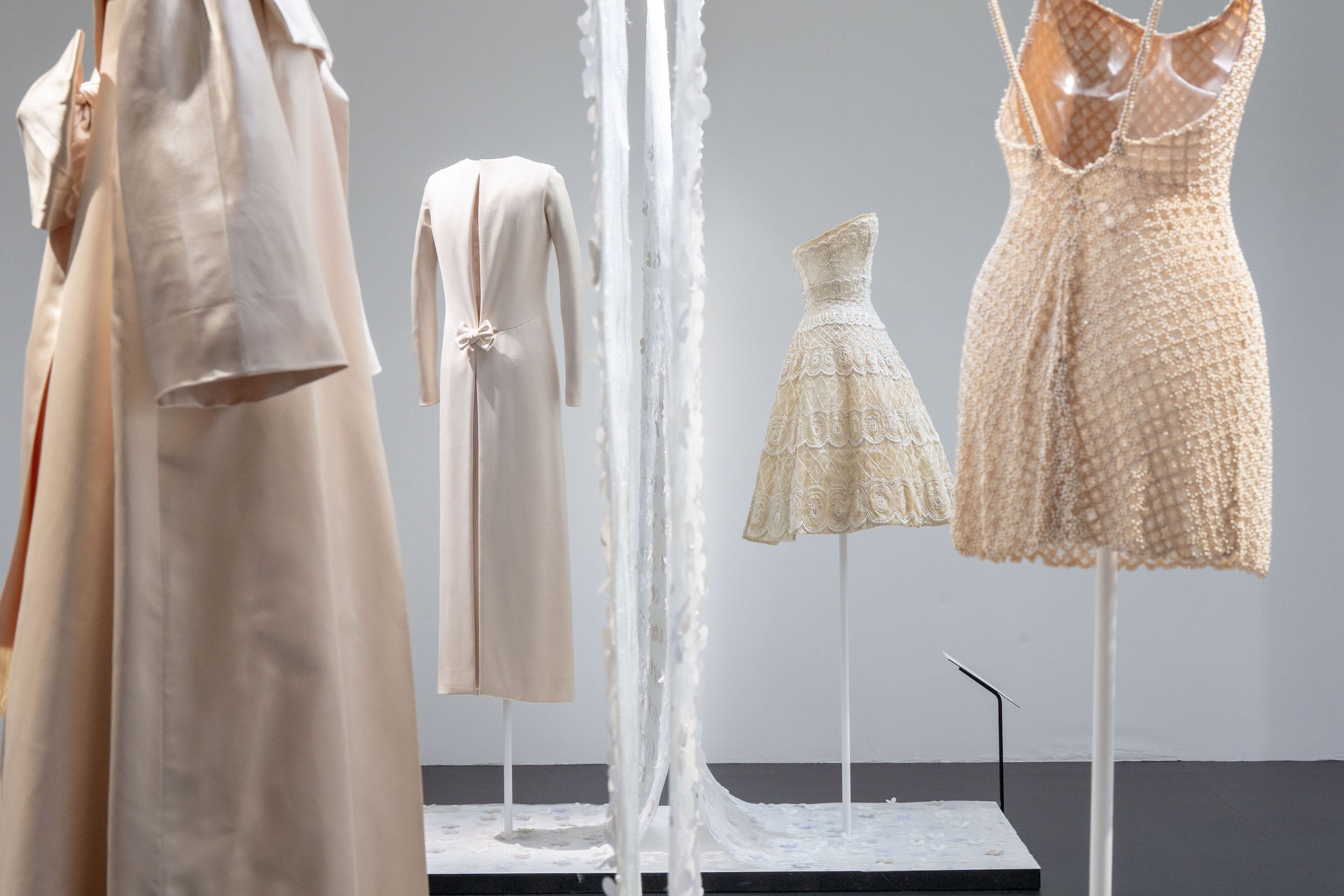 Azzedine Alaia and Christian Dior haute couture gowns displayed on mannequins in museum installation