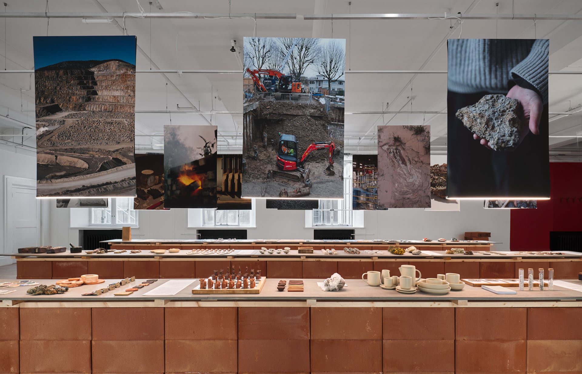 GLOST London glaze shop exhibition with hanging photographs and ceramic material samples on brick plinth