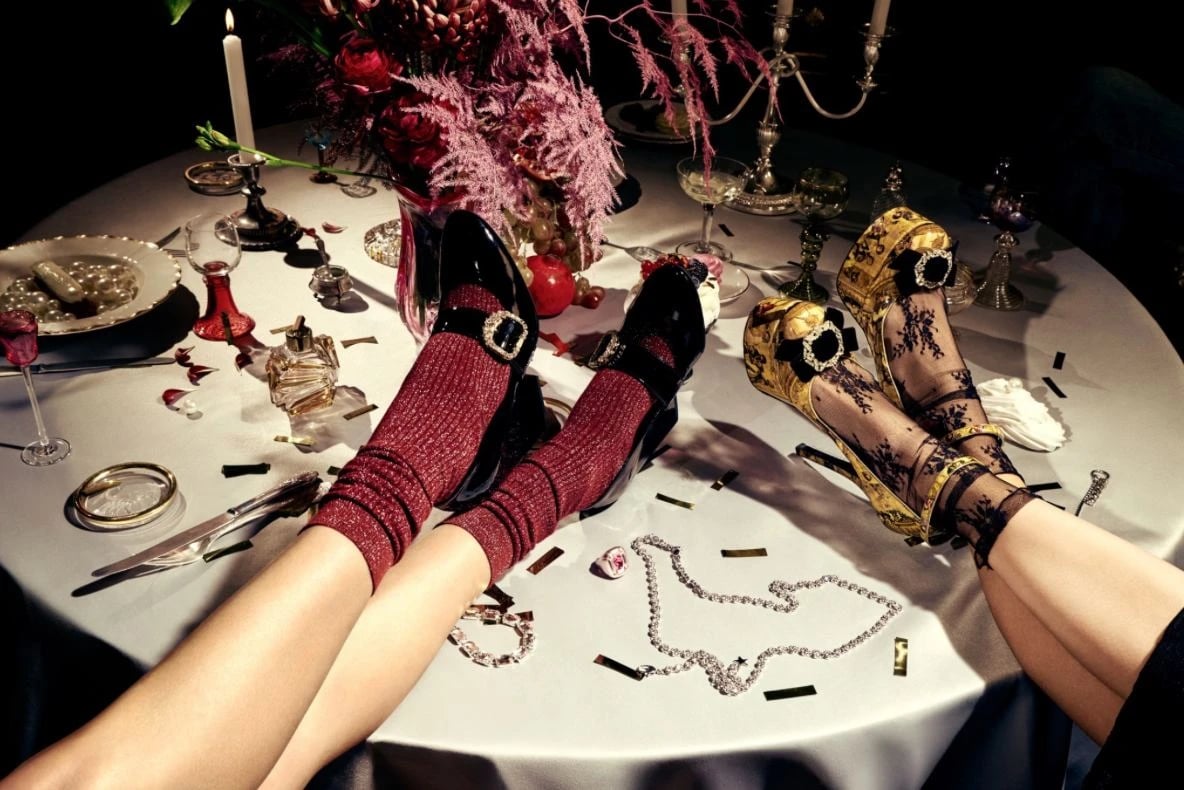 Flacon Magazine x Gold Apple editorial: two pairs of legs on a dinner table wearing embellished mary janes and baroque heels
