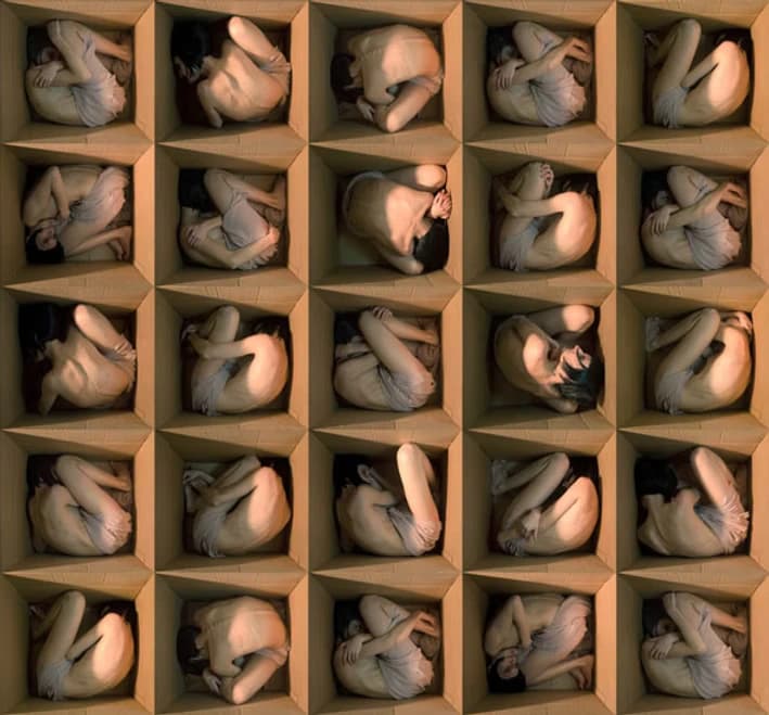 Alicia Moneva A large collection of nearly nude figures is enclosed in open wooden boxes.