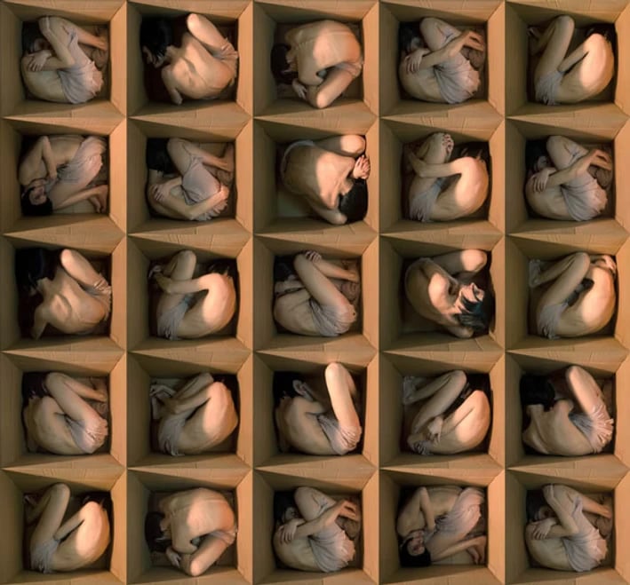 Alicia Moneva A large collection of nearly nude figures is enclosed in open wooden boxes.