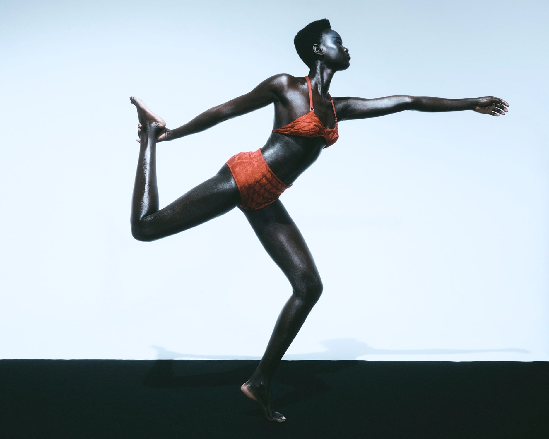 BRUNO+NICO, A woman wearing a red bikini stands in dancer pose against a pale blue background, with her left arm extended facing the right of the image. Featured image from Chan, for Les Echos. Courtesy of Bruno+Nico.