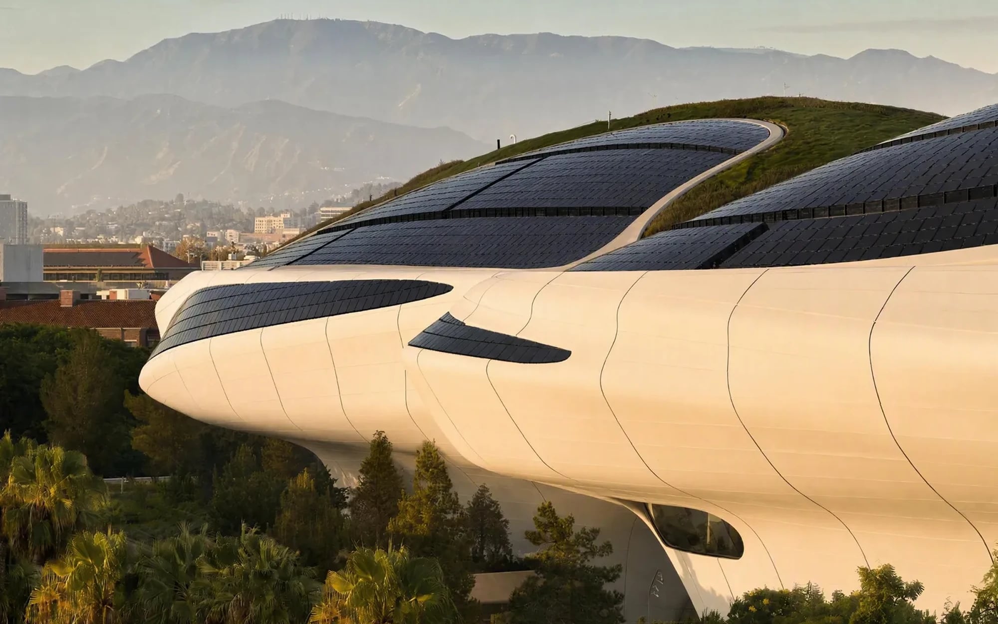 Lucas Museum of Narrative Art futuristic white curved building with solar panels against Los Angeles skyline