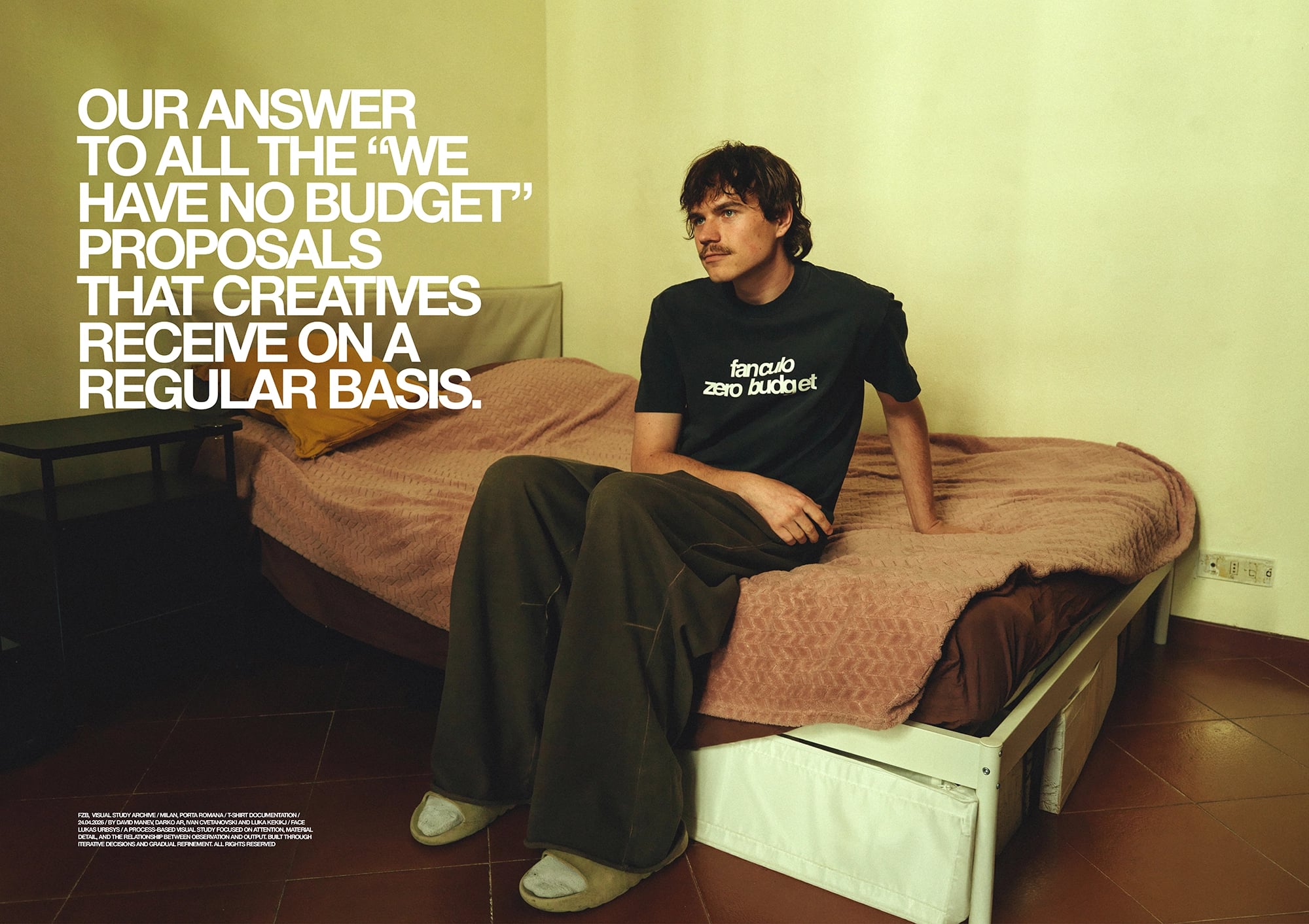 Campaign image showing a person seated on a bed wearing a black T-shirt and wide-leg trousers, with large white typography reading "Our answer to all the 'we have no budget' proposals that creatives receive on a regular basis."